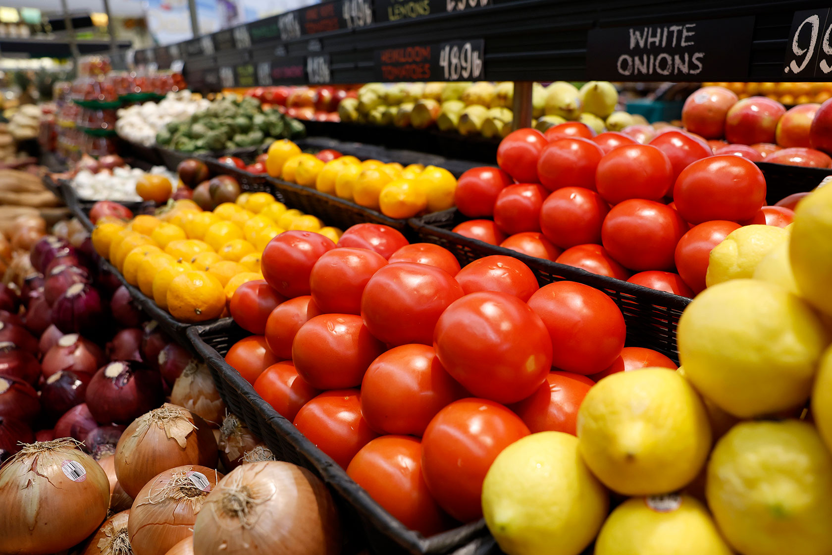 Tomatoes and other produce in bins for sale