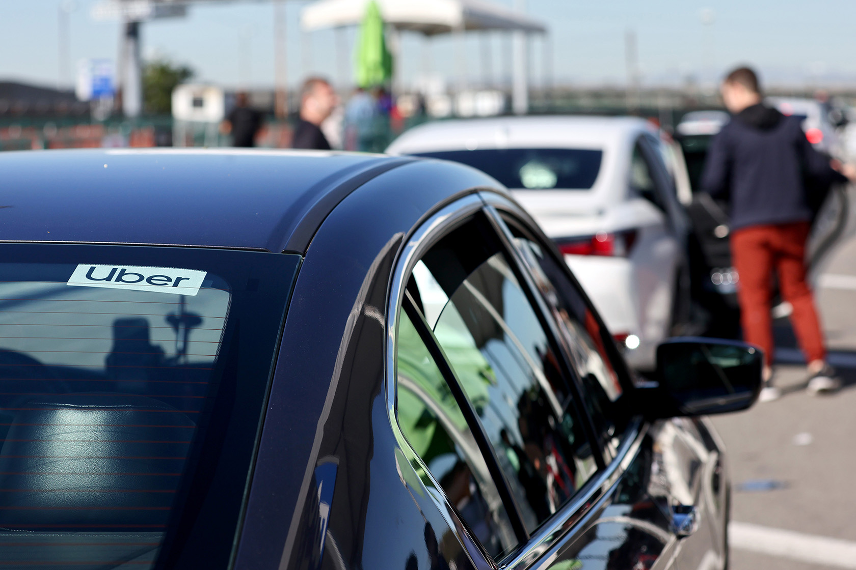 Rideshare vehicles wait in line to pick up passengers.