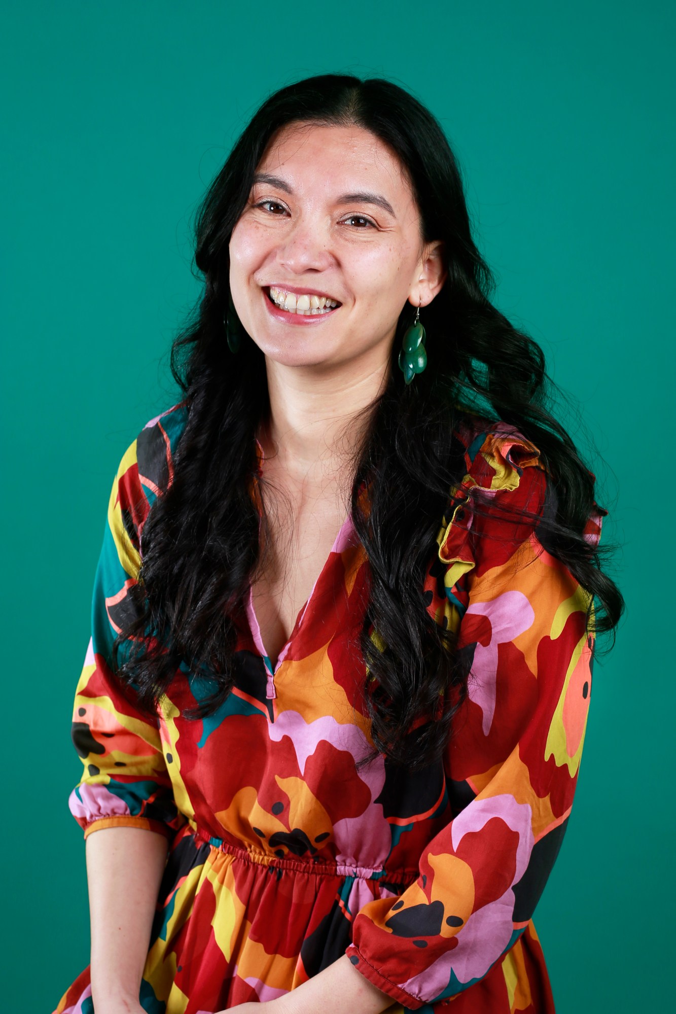 Photo of Regina Barber in front of a green background.