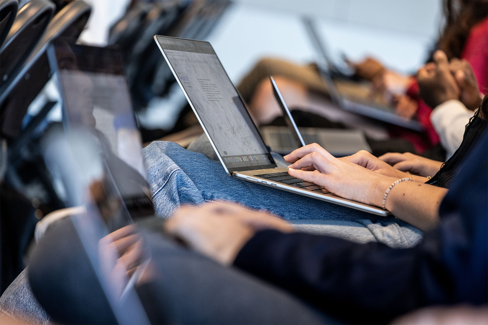 Students type on laptop computers during a class.