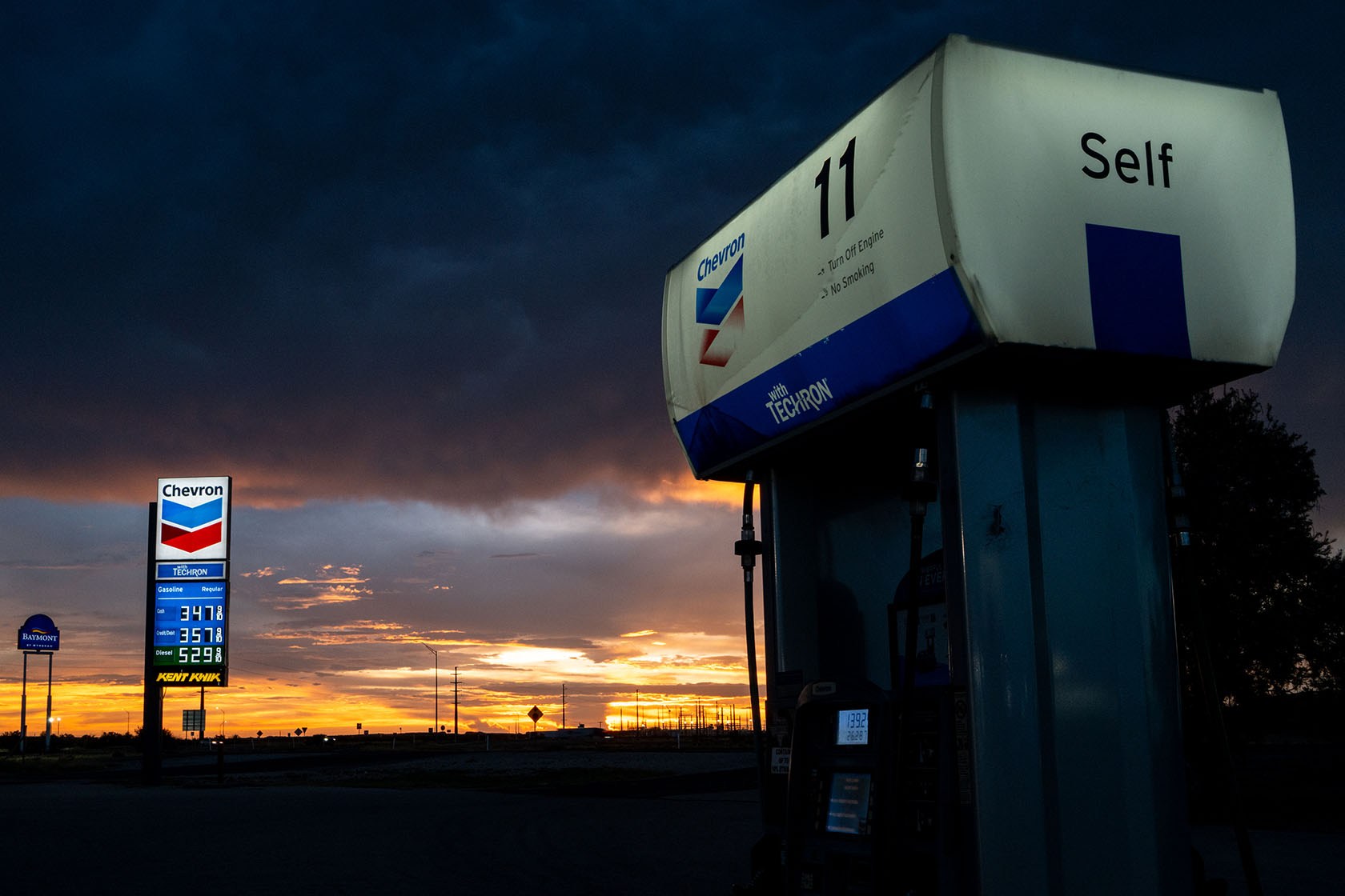 A gas station at sunset with high diesel prices displayed