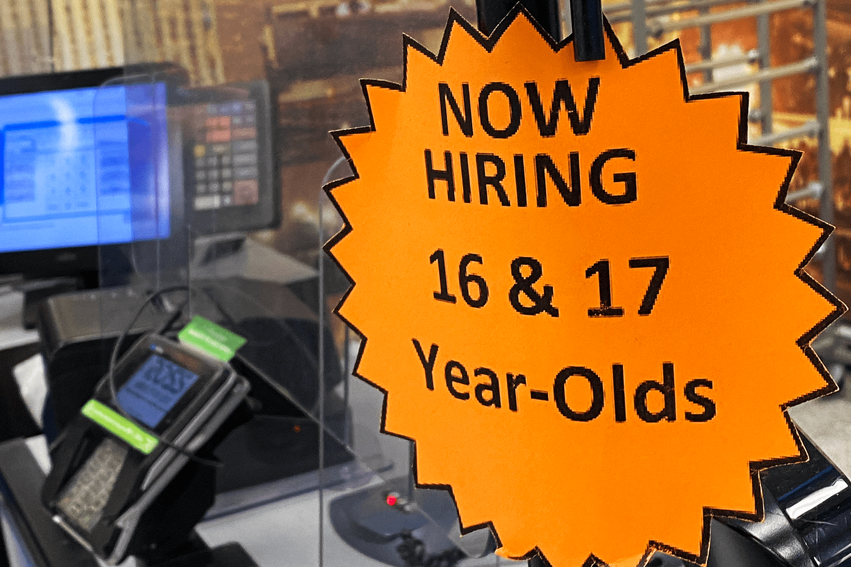 Signage advertises that a store is hiring for 16- and 17-year-olds