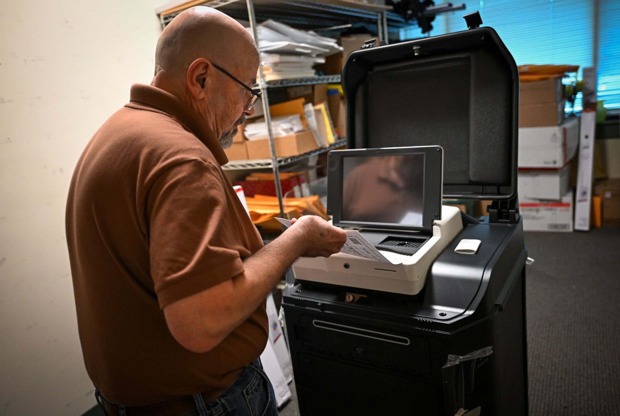 A man demonstrates how the new voting machines work using a sample ballot.