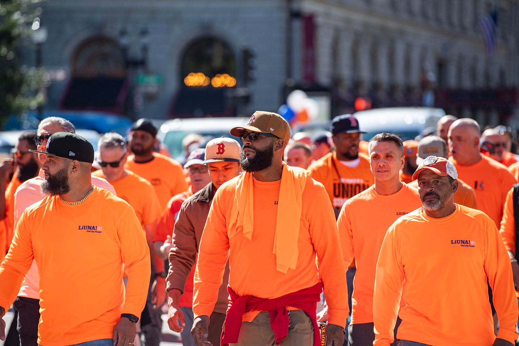 A large group of union members in matching orange LiUNA! shirts participate in an outdoor march.