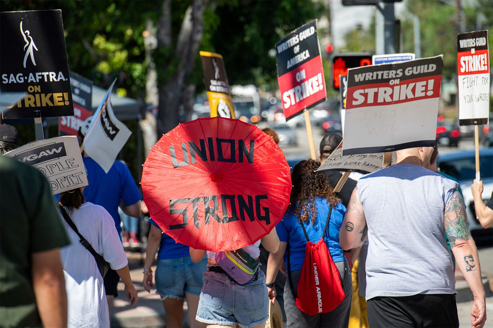 Picketers carrying SAG-AFTRA and Writers Guild 