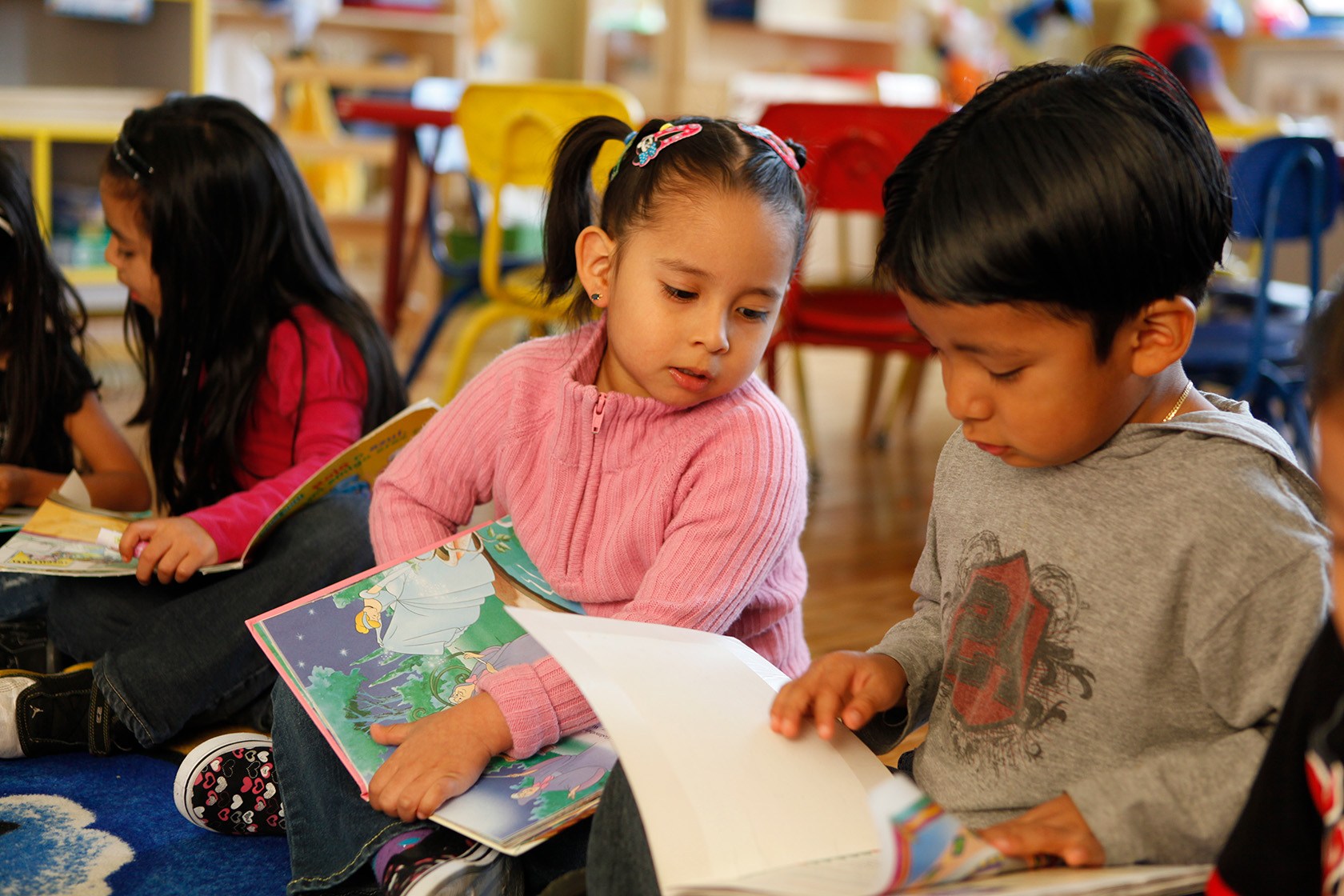 Children enrolled in a Head Start program read books together.